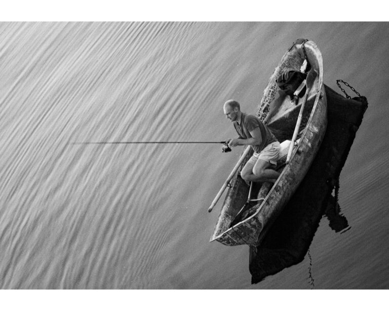 A black and white photo of a fisherman